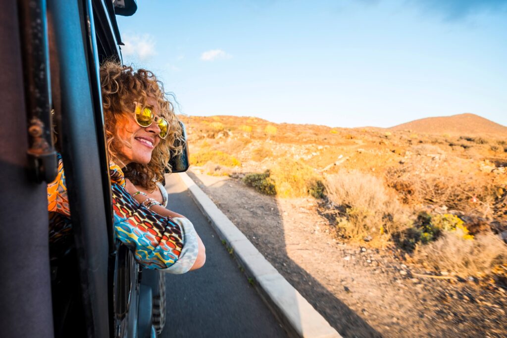 Woman smiling on road trip through desert