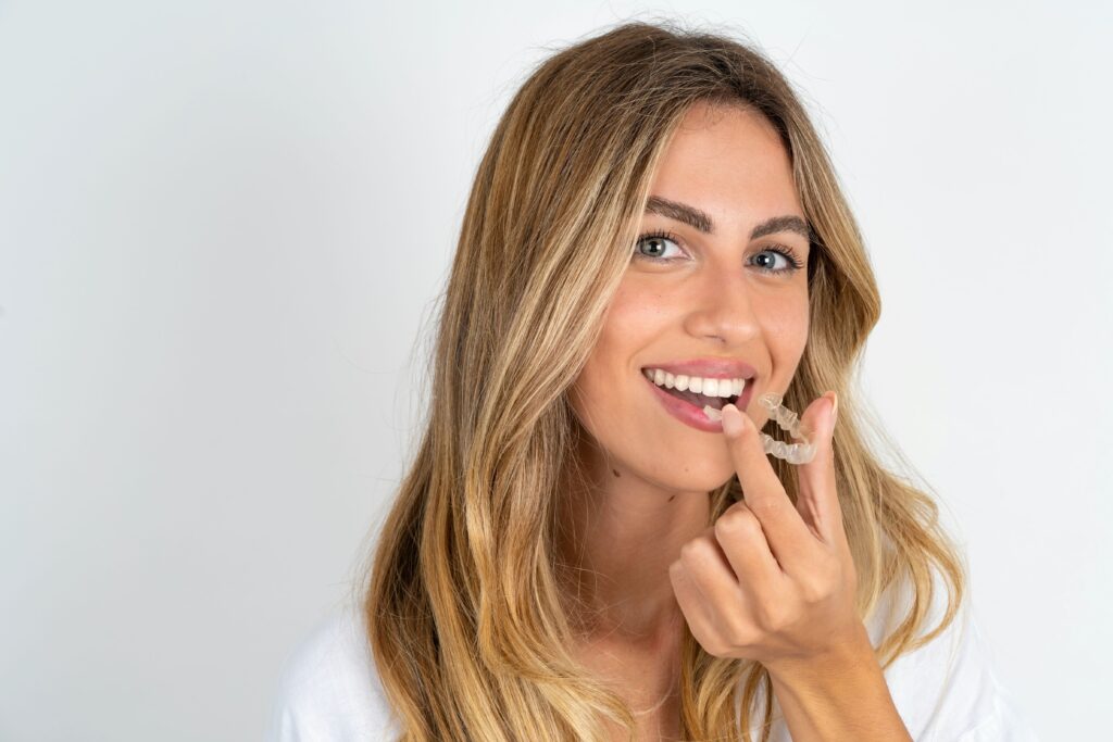 Woman holding Invisalign to her mouth